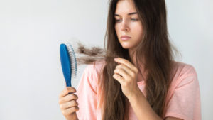 A queda de cabelo ocorre toda vez que manuseamos os fios, seja na hora da lavagem, quando penteamos ou passamos a mão. Por isso, quando a queda é composta por uma grande quantidade de fios, deve-se averiguar a causa, já que ela pode estar relacionada a um desequilíbrio hormonal do organismo. Os cabelos possuem um forte apelo estético. Apesar de terem apenas a função de proteger o couro cabeludo da incidência solar, eles emolduram o rosto e estão associados à vitalidade, beleza e saúde. O ser humano perde, por dia, uma média de 150 fios de cabelo. Entenda quando a queda de cabelo é resultado de problemas hormonais, a seguir. O que pode provocar a queda de cabelo? Vários podem provocar a queda de cabelo. Entre eles estão a anemia, estresse, excesso de vitaminas, gravidez, uso de medicamentos, maus hábitos, fatores emocionais e desequilíbrio hormonal. Para evitar que o problema se torne crônico, levando a um quadro de alopecia, deve-se procurar um médico especialista, para investigação da causa e tratamento. Quando a queda de cabelo é derivada de um problema no sistema endócrino, alguns hormônios podem ser os causadores. Descubra, a seguir. Queda de cabelo por desequilíbrio hormonal Alterações nos hormônios T3 e T4 Problemas na tireoide, como hipotireoidismo e hipertireoidismo, podem causar a queda de cabelo. A tireoide é uma glândula localizada na região do pescoço. Sua principal função é produzir os hormônios tiroxina (T4) e  triiodotironina (T3). Quando essas substâncias estão em quantidades alteradas no organismo, elas causam diversos desequilíbrios. E, consequentemente, podem prejudicar a produção dos fios de cabelo. Por afetar diretamente a vitalidade, essas alterações prejudicam os fios. Com isso, eles se tornam finos, fracos, secos, opacos, descoloridos e com maior tendência à quebra e queda. Cortisol Conhecido como o hormônio do estresse, o cortisol é importante porque atua no controle do estresse. Outras funções da substância são a redução de inflamações e a manutenção dos níveis de açúcar no sangue, contribuindo, também, para o sistema imunológico. Além do uso de medicamentos, níveis altos de cortisol podem ser provocados quando um indivíduo passa por um constante período de estresse. Isso acontece porque em pessoas que sofrem de estresse crônico, sua produção é contínua. Logo, dentre os sintomas do excesso de cortisol está a queda acentuada de cabelo, por exemplo.  Testosterona A testosterona é o hormônio que pode provocar a queda de cabelo mais temida por homens e mulheres. Este hormônio é um dos responsáveis por causar a calvície. A alopecia androgenética provocada pela testosterona afeta 50% dos homens aos 50 anos e 40% das mulheres após a menopausa. A queda dos cabelos ocorre porque o DTH, substância derivada da testosterona, interage, de forma excessiva, com os receptores de andrógenos presentes nos folículos pilosos. Essa interação provoca a atrofia dos bulbos capilares. Consequentemente, deixa os cabelos mais finos e acelerando a queda definitiva. Controle do desequilíbrio hormonal e da queda de cabelo O desequilíbrio hormonal pode provocar muito mais do que a queda de cabelo: essa situação é um sério fator de risco para inúmeras doenças. Diante disso, observe e conheça o seu corpo e, a qualquer sinal de alteração, procure um médico. Assim como outras disfunções, os problemas hormonais, quanto antes descobertos, mais fáceis serão tratados. Quer saber mais? Clique no banner e saiba mais sobre Medicina Integrativa.