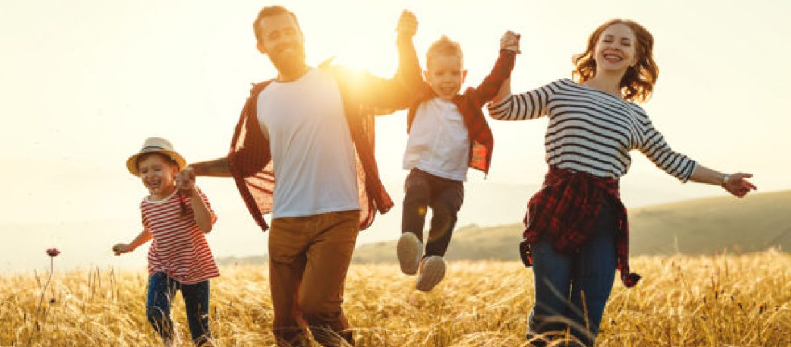 Happy family father of mother and child son  on nature at sunset