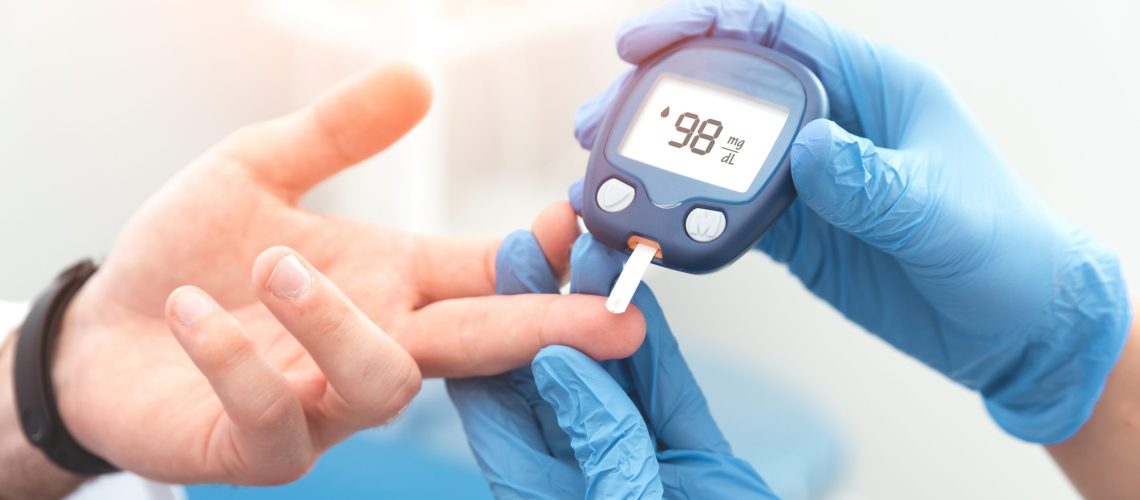 Doctor checking blood sugar level with glucometer. Treatment of diabetes concept.