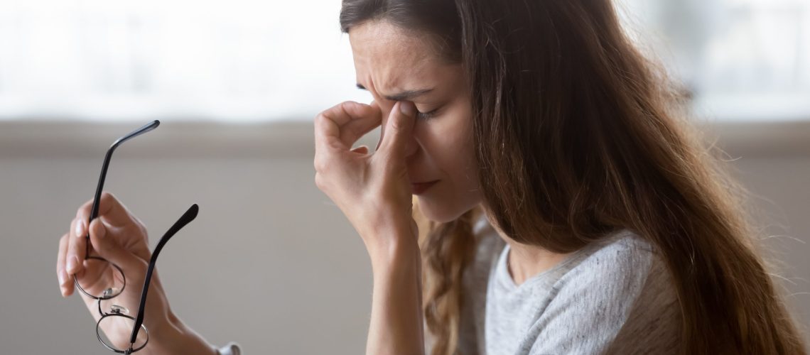 Close up exhausted woman massaging eyelids, taking off glasses, tired freelancer or student suffering from eyestrain or dry eye syndrome, feeling dizziness or headache after long hours work