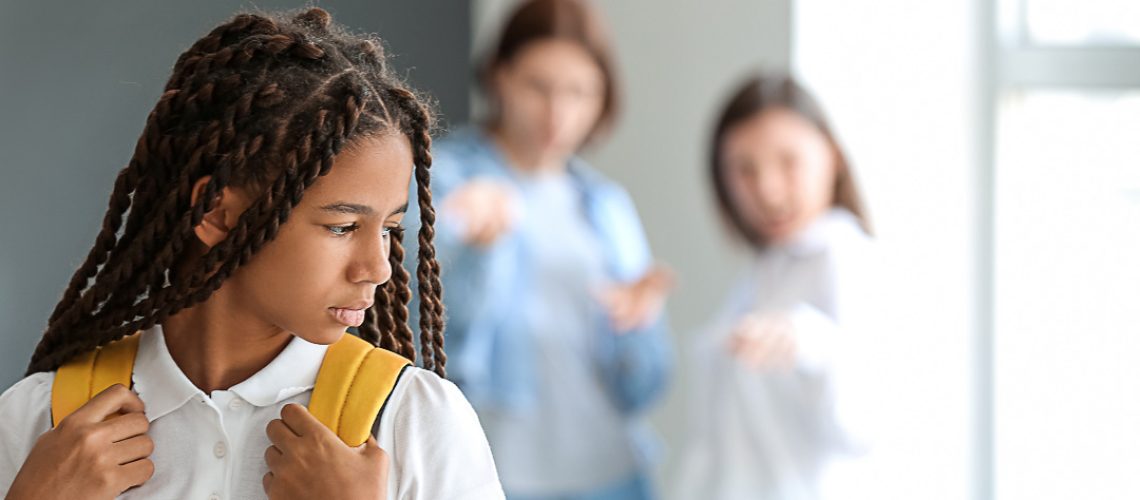 Pupils bullying African-American girl at school. Stop racism