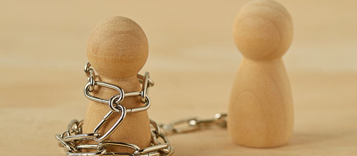Wooden pawn with chains controlled by his partner - Concept of toxic relationship, love, domination and control