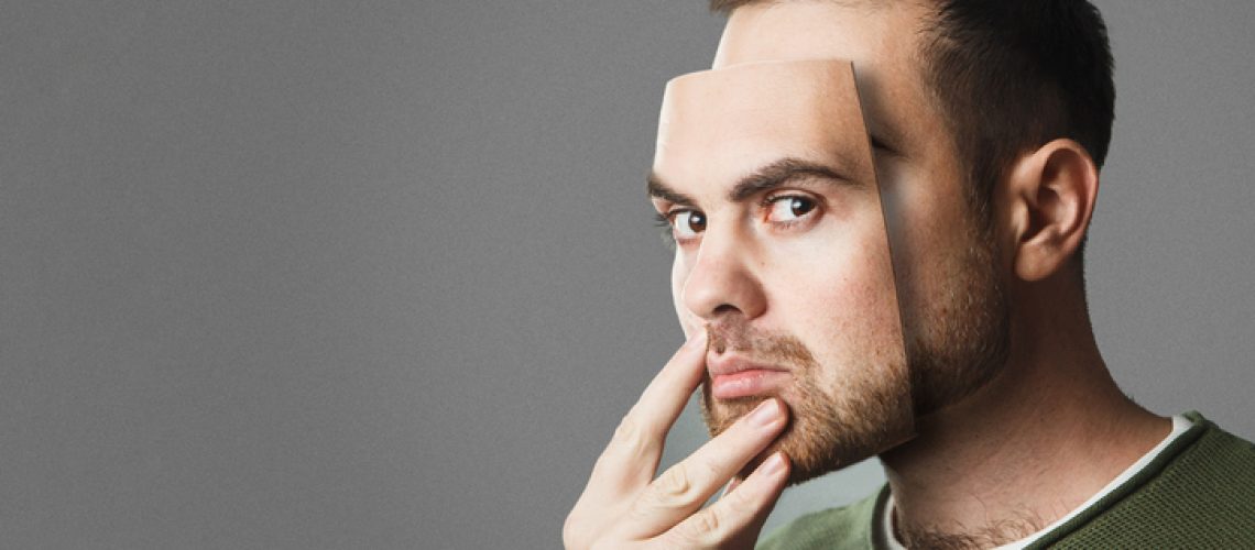 Be Yourself. Handsome man holds a mask of his face. Copy space.