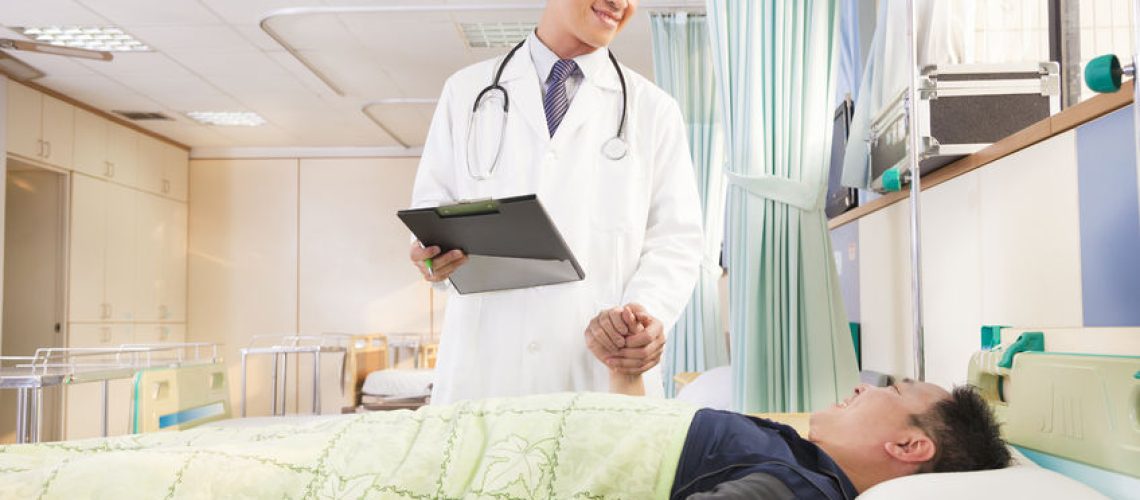 26273955 - smiling  doctor holding patient hand to encourage him