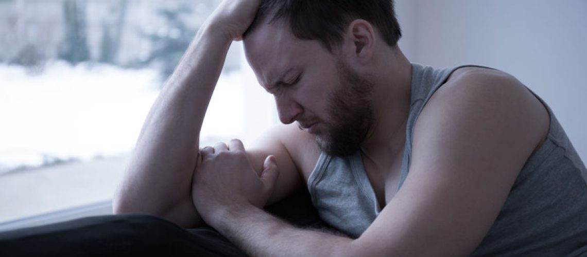 47721890 - heartbroken young man sitting on the bed