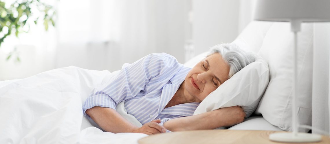 old age and people concept - senior woman sleeping in bed at home bedroom