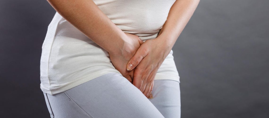 Young sick woman with hands holding pressing her crotch lower abdomen. Medical or gynecological problems, healthcare concept